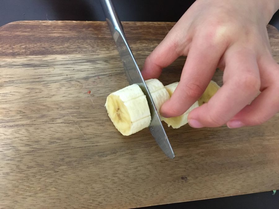 バナナを切る子どもの手