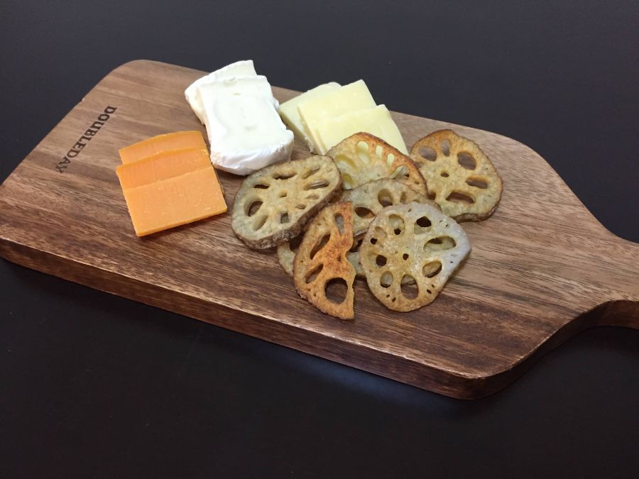 カッティングボードの上にのったチーズとレンコンチップス